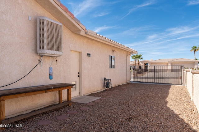 view of side of property with central AC unit, fence, an outbuilding, and stucco siding