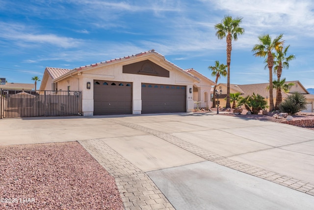 ranch-style house with a garage, a gate, concrete driveway, and stucco siding