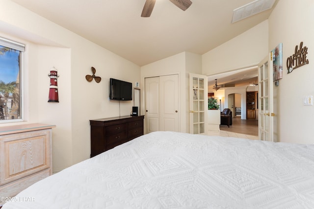 bedroom featuring arched walkways, visible vents, vaulted ceiling, french doors, and a closet