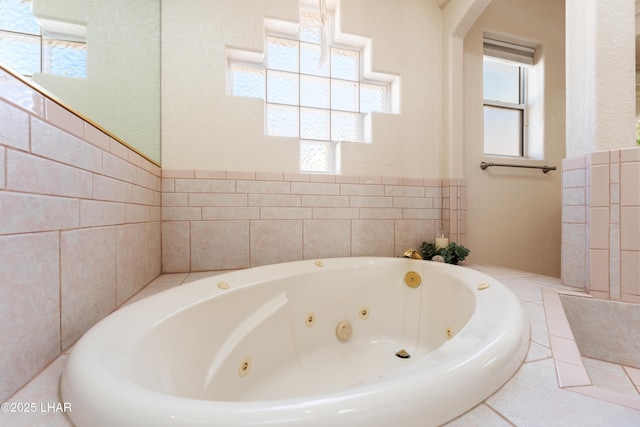 bathroom with a healthy amount of sunlight and a tub with jets