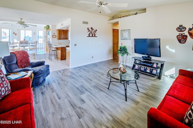 living room with lofted ceiling, ceiling fan, and light hardwood / wood-style flooring