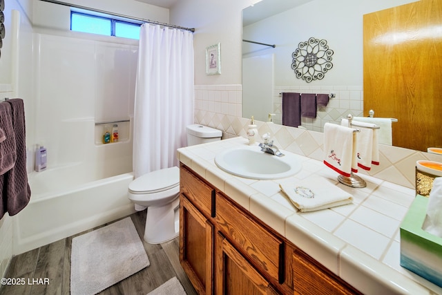 full bathroom with shower / tub combo with curtain, toilet, tile walls, vanity, and hardwood / wood-style flooring