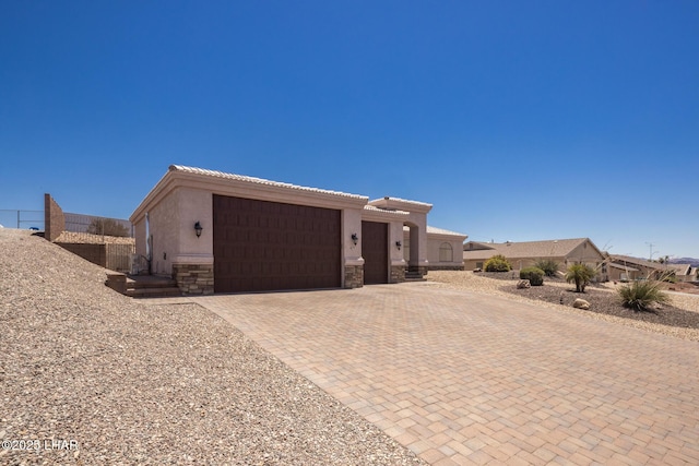 679 Apache Dr, Lake Havasu City, AZ 86406 - view of front facade featuring a garage, stucco siding, stone siding, and decorative driveway
