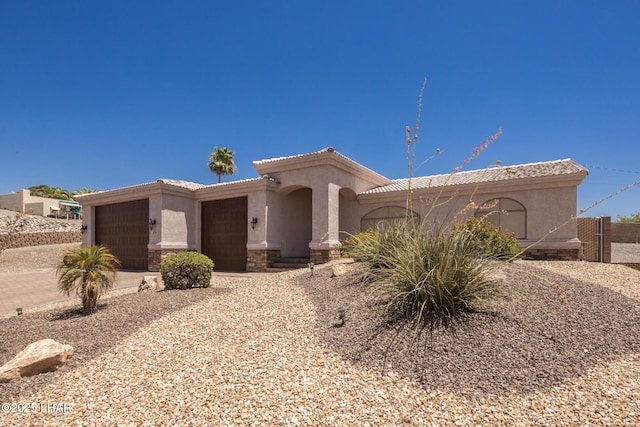 679 Apache Dr, Lake Havasu City, AZ 86406 - view of front of home with a garage, stucco siding, concrete driveway, a tile roof, and stone siding