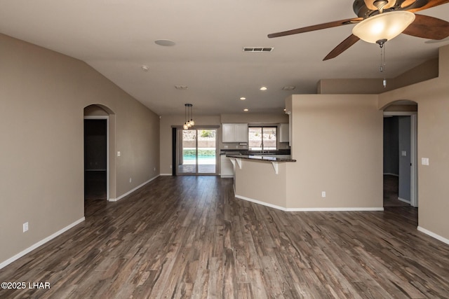 679 Apache Dr, Lake Havasu City, AZ 86406 - unfurnished living room with arched walkways, ceiling fan, dark wood finished floors, vaulted ceiling, and recessed lighting