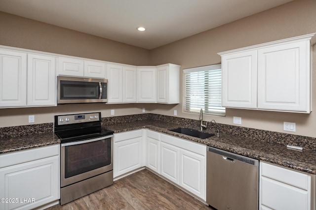 679 Apache Dr, Lake Havasu City, AZ 86406 - kitchen featuring appliances with stainless steel finishes, wood finished floors, white cabinetry, dark stone countertops, and recessed lighting
