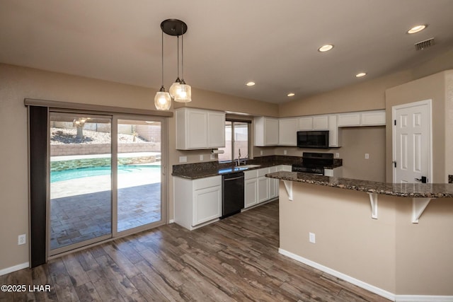 679 Apache Dr, Lake Havasu City, AZ 86406 - kitchen featuring black appliances, dark stone countertops, white cabinetry, dark wood finished floors, and a breakfast bar