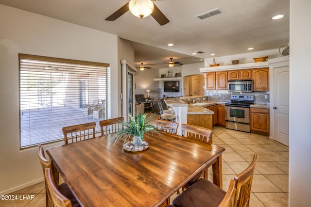 dining room with ceiling fan, sink, and light tile patterned floors