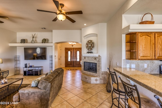 living room with ceiling fan with notable chandelier and light tile patterned floors