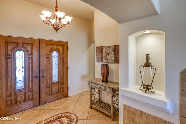 tiled entrance foyer with a chandelier