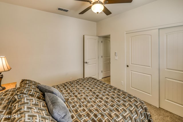 carpeted bedroom with ceiling fan and a closet