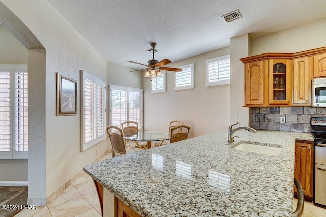 1650 Smoketree Ave Unit 202, Lake Havasu City, AZ 86403 - kitchen with sink, a textured ceiling, appliances with stainless steel finishes, light stone countertops, and backsplash