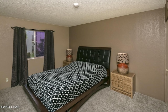 bedroom with light carpet and a textured ceiling