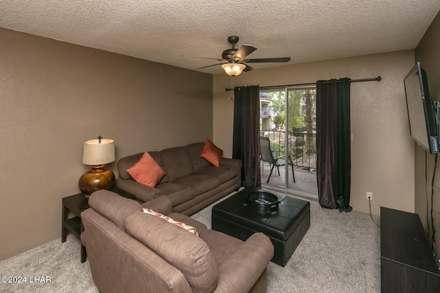 living room with ceiling fan, carpet flooring, and a textured ceiling