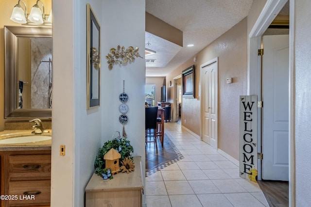 777 Harrah Way Unit 112, Lake Havasu City, AZ 86403 - corridor featuring light tile patterned floors, a textured ceiling, visible vents, a sink, and baseboards