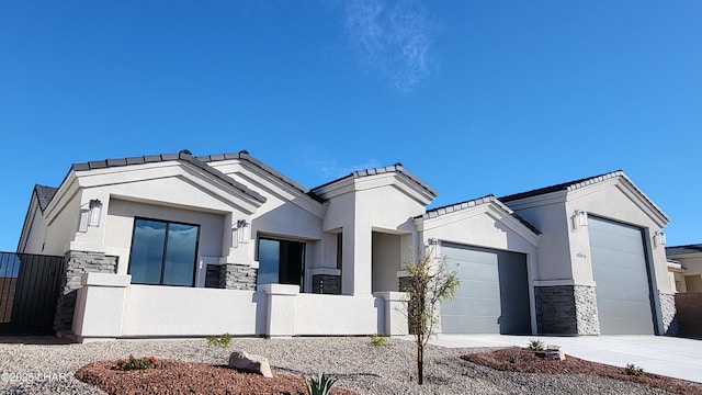 view of front facade with a fenced front yard, a garage, stone siding, concrete driveway, and stucco siding