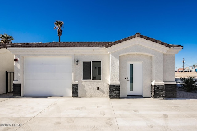 2080 Swanson Ave Unit F, Lake Havasu City, AZ 86403 - view of front of home with concrete driveway, an attached garage, stone siding, and stucco siding