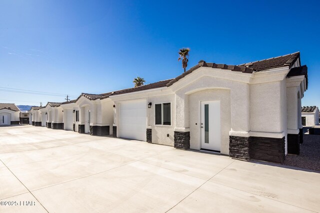 2080 Swanson Ave Unit F, Lake Havasu City, AZ 86403 - mediterranean / spanish home with driveway, a garage, stucco siding, and stone siding