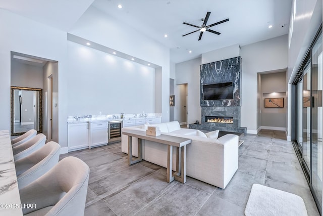 816 Isola Bella Loop, Lake Havasu City, AZ 86403 - living room with beverage cooler, ceiling fan, a high end fireplace, recessed lighting, and a towering ceiling
