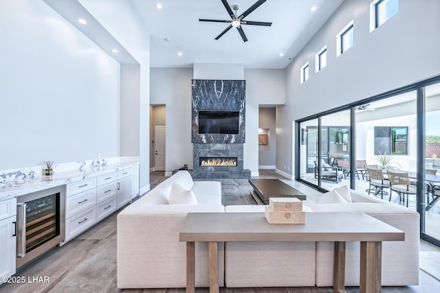 816 Isola Bella Loop, Lake Havasu City, AZ 86403 - living area with beverage cooler, recessed lighting, a fireplace, ceiling fan, and a towering ceiling