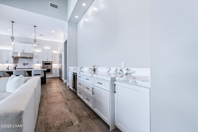 816 Isola Bella Loop, Lake Havasu City, AZ 86403 - kitchen featuring under cabinet range hood, recessed lighting, tasteful backsplash, white cabinetry, and beverage cooler