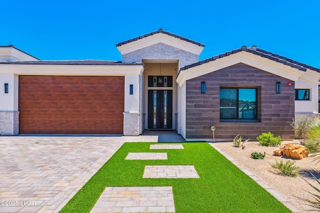 816 Isola Bella Loop, Lake Havasu City, AZ 86403 - view of front facade with an attached garage, a front lawn, decorative driveway, and stucco siding