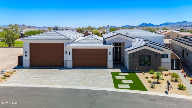 816 Isola Bella Loop, Lake Havasu City, AZ 86403 - modern home with an attached garage, decorative driveway, a mountain view, a tile roof, and stucco siding