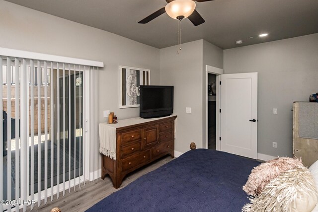 bedroom featuring access to exterior, light hardwood / wood-style floors, and ceiling fan