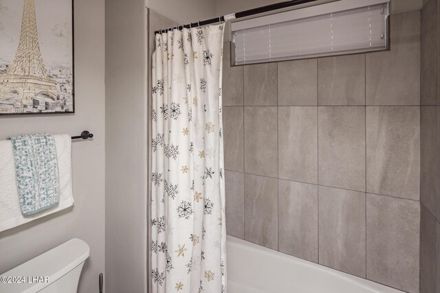 bathroom with shower / bath combo and toilet