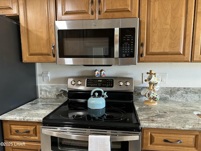 kitchen with appliances with stainless steel finishes and light stone countertops