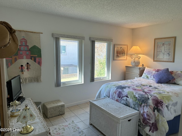 bedroom featuring light tile patterned floors and a textured ceiling