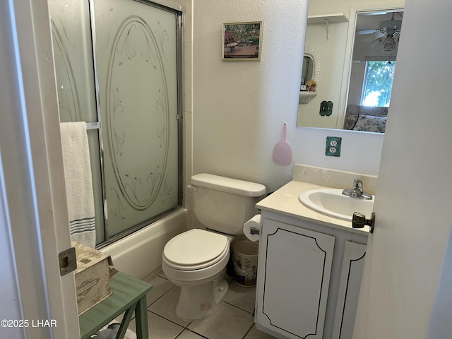 full bathroom with toilet, ceiling fan, combined bath / shower with glass door, tile patterned floors, and vanity