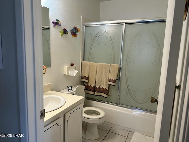 full bathroom featuring tile patterned floors, toilet, vanity, and shower / bath combination with glass door