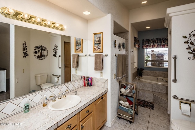 bathroom with vanity, toilet, tile patterned flooring, and tiled tub