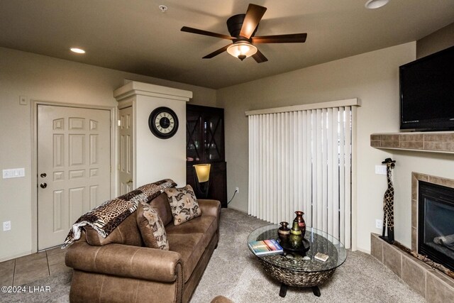 living room with ceiling fan, tile patterned floors, and a tiled fireplace