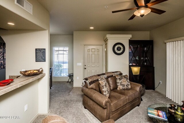 carpeted living room with ceiling fan