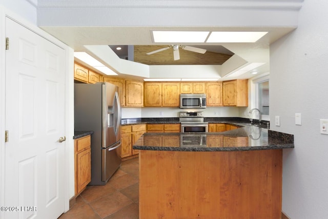 2624 Rainbow Ave N, Lake Havasu City, AZ 86403 - kitchen featuring dark stone countertops, a ceiling fan, a peninsula, a sink, and appliances with stainless steel finishes