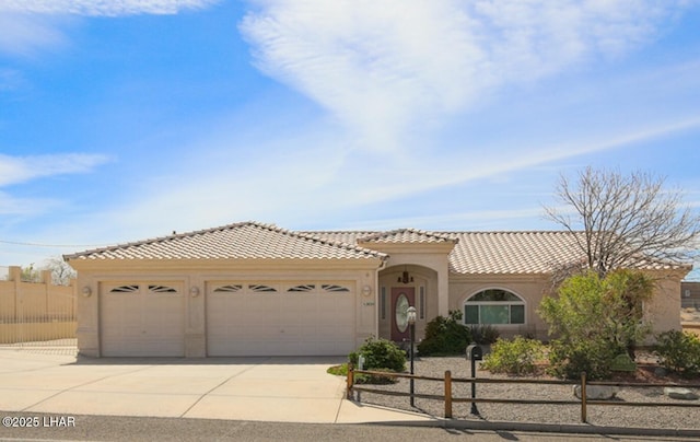 2624 Rainbow Ave N, Lake Havasu City, AZ 86403 - mediterranean / spanish-style home with stucco siding, driveway, a tile roof, fence, and an attached garage