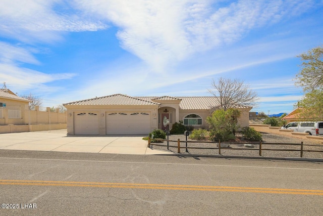 2624 Rainbow Ave N, Lake Havasu City, AZ 86403 - mediterranean / spanish home featuring fence, an attached garage, stucco siding, concrete driveway, and a tile roof