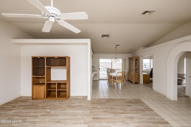 interior space with ceiling fan, vaulted ceiling, and light hardwood / wood-style flooring