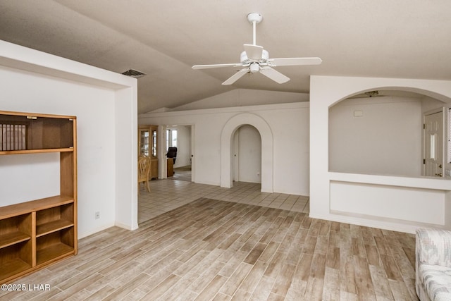 unfurnished living room featuring ceiling fan, vaulted ceiling, and light wood-type flooring