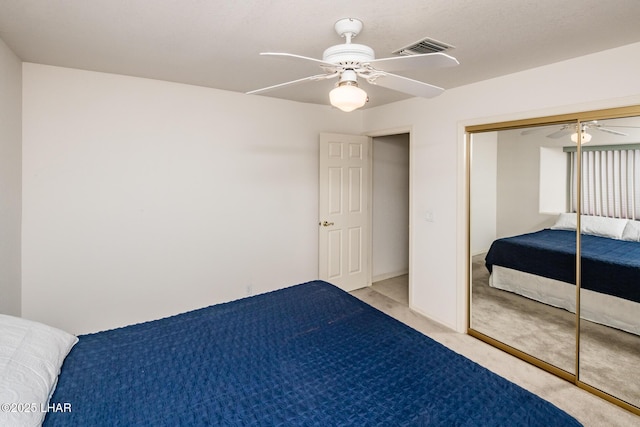 unfurnished bedroom with ceiling fan, light colored carpet, and a closet