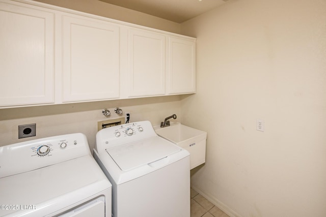 clothes washing area with separate washer and dryer, sink, cabinets, and light tile patterned flooring