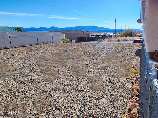 view of yard featuring fence and a mountain view