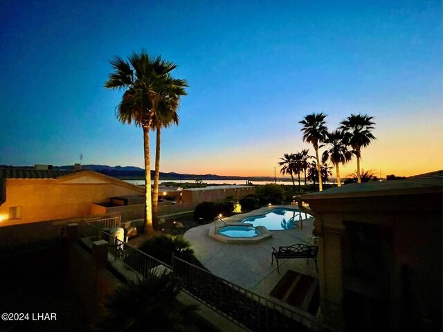 pool at dusk featuring a patio