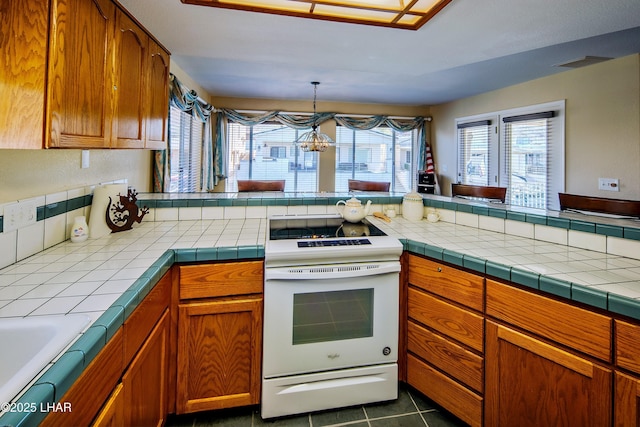 8731 Yaqui, Parker, AZ 85344 - kitchen with visible vents, brown cabinetry, white electric range, and dark tile patterned floors