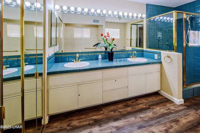 8731 Yaqui, Parker, AZ 85344 - full bath with double vanity, a sink, a shower stall, and wood finished floors
