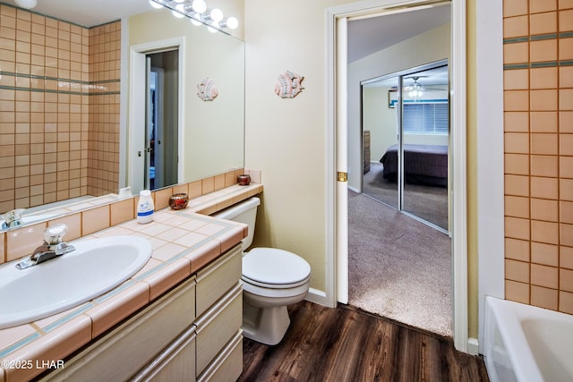 8731 Yaqui, Parker, AZ 85344 - full bathroom featuring baseboards, wood finished floors, toilet, vanity, and a tub