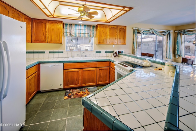 8731 Yaqui, Parker, AZ 85344 - kitchen with a sink, a tray ceiling, tile countertops, and white appliances