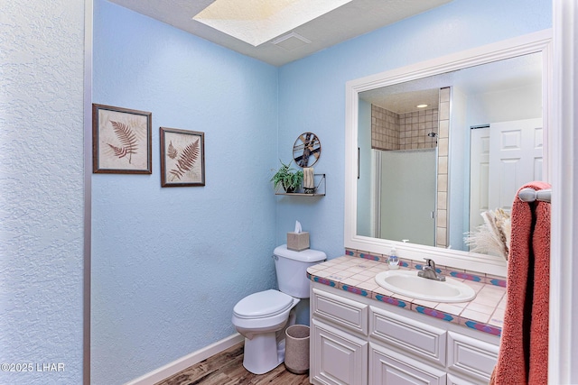 875 Wallingford Pl, Lake Havasu City, AZ 86406 - bathroom with a skylight, wood finished floors, vanity, a textured wall, and a shower